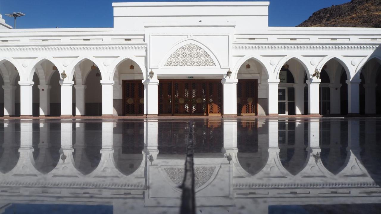 Intercontinental Dar Al Hijra Madinah, An Ihg Hotel Medina Exterior photo The photo shows a stunning white building with a symmetrical facade. It features several arched doorways and windows, which are typical of Islamic architectural design. The surface in front appears to be a smooth, reflective material, likely water or